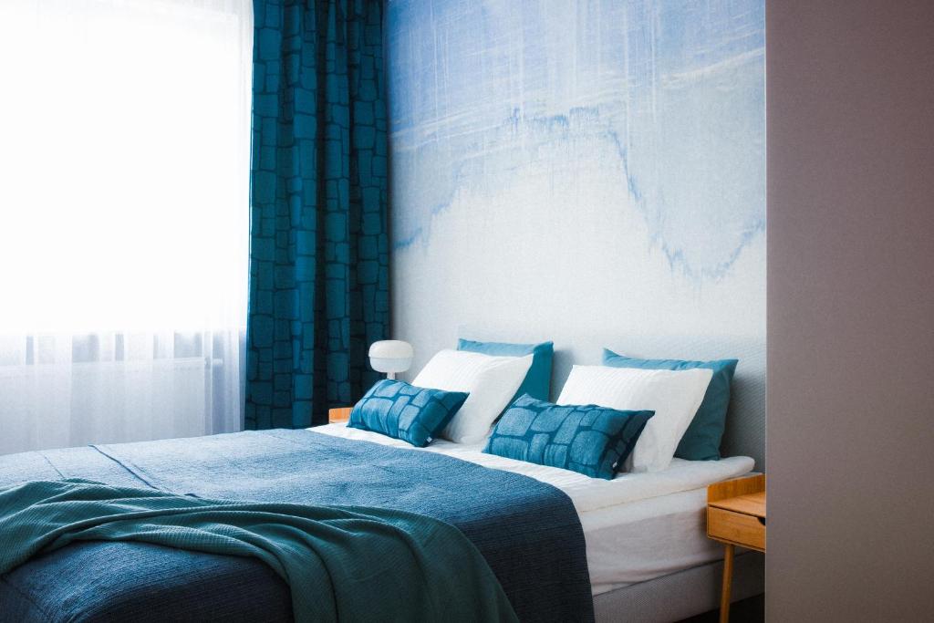 a bedroom with a bed with blue and white pillows at Apartamenty Blue in Biała Podlaska