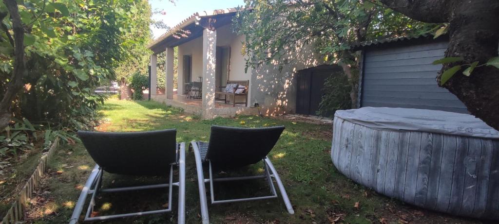 two chairs sitting in the grass in front of a house at Chambre d&#39;hôte Amouratcha in Fabrègues