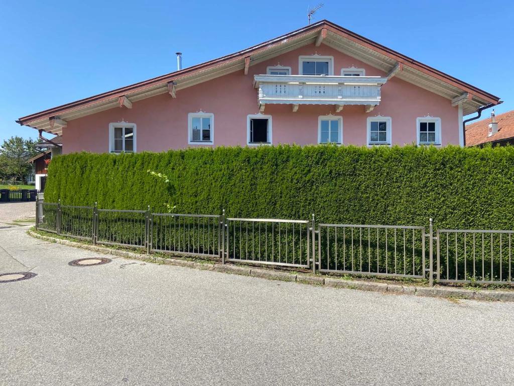 a pink house with a hedge in front of it at Haus Seerose in Taching am See
