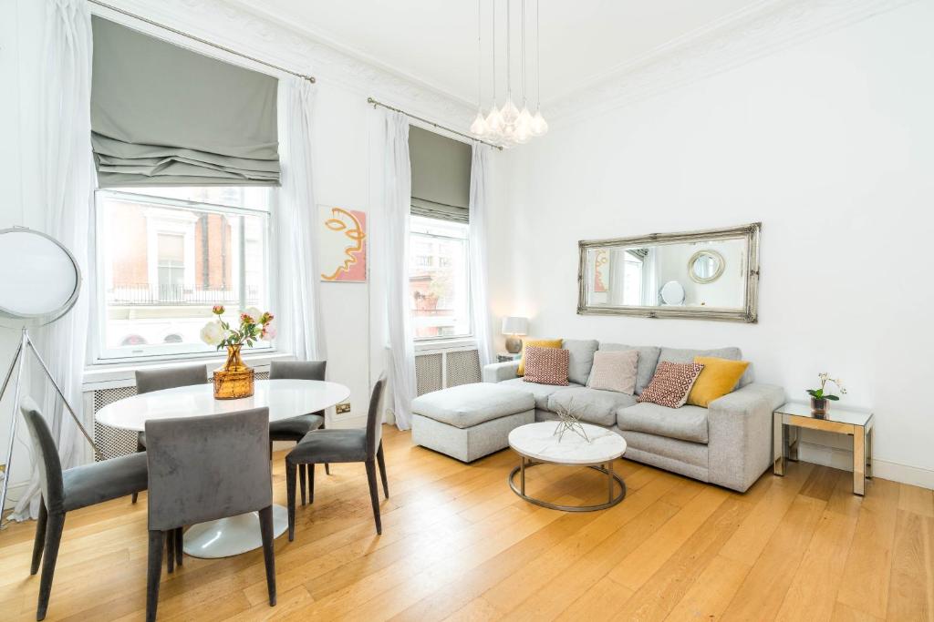 een woonkamer met een bank en een tafel bij Spacious 2 bedroom / Gloucester Road / Kensington in Londen