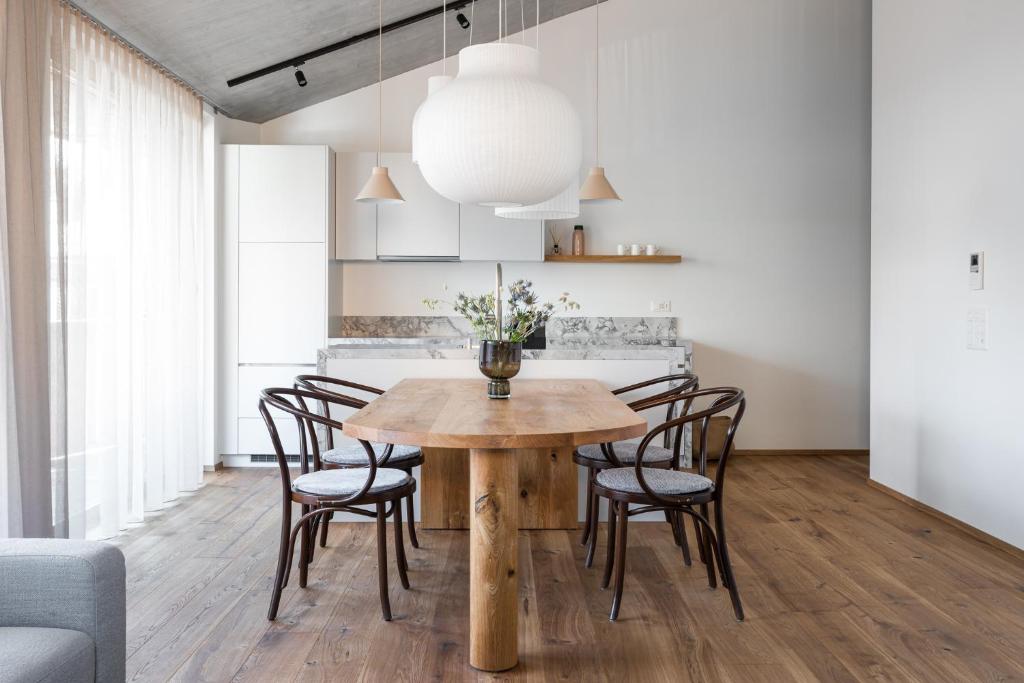 uma sala de jantar com uma mesa de madeira e cadeiras em Casa Flurina em Flims