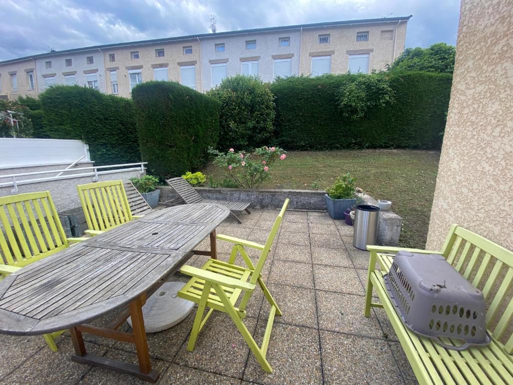 a picnic table and chairs on a patio at Agréables chambres dans maison suspendue in Saint-Étienne