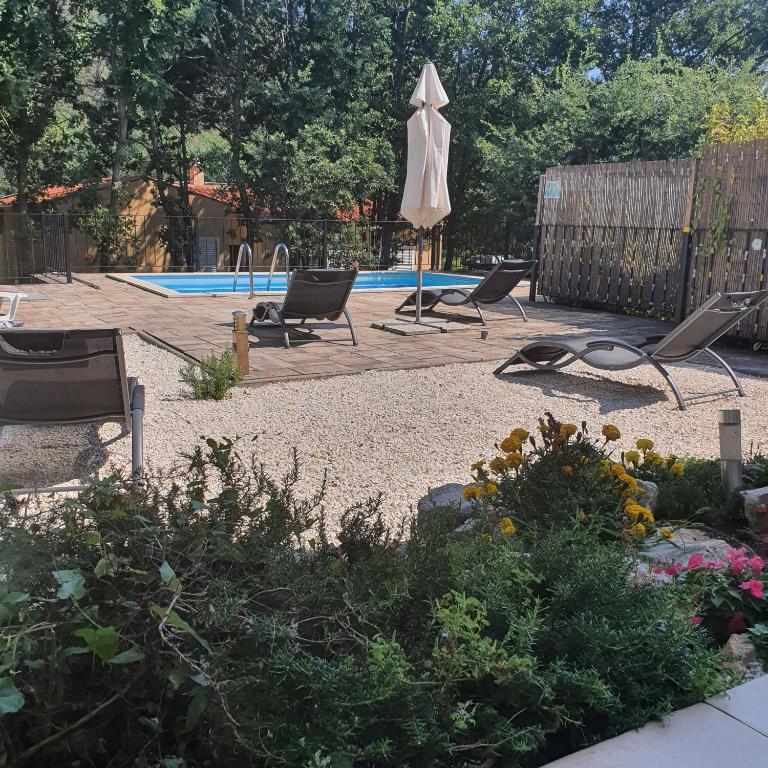 a patio with chairs and an umbrella and a pool at Dee's House and Pool in Labin