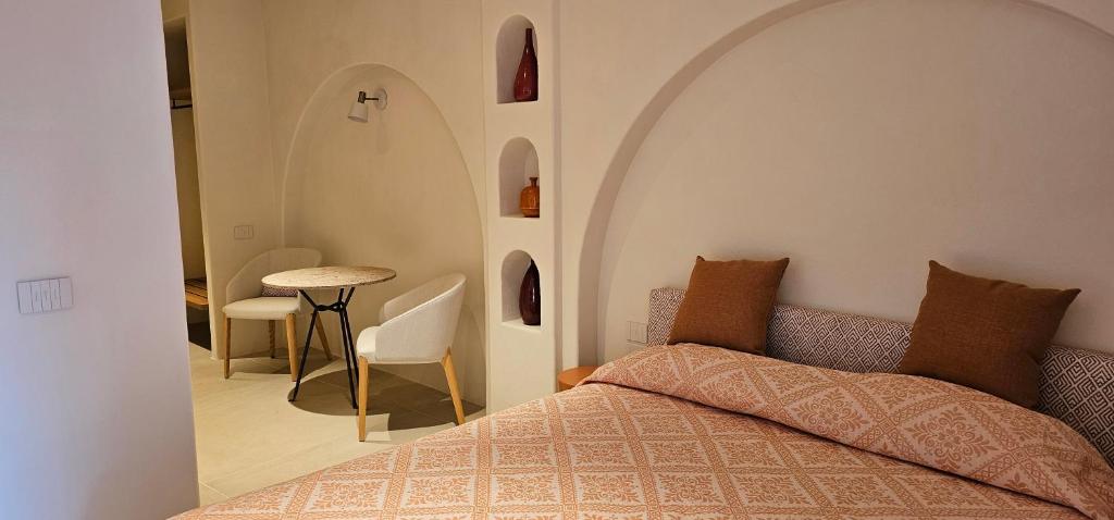 1 dormitorio con 1 cama, mesa y sillas en Green Park Hotel en Porto Cervo