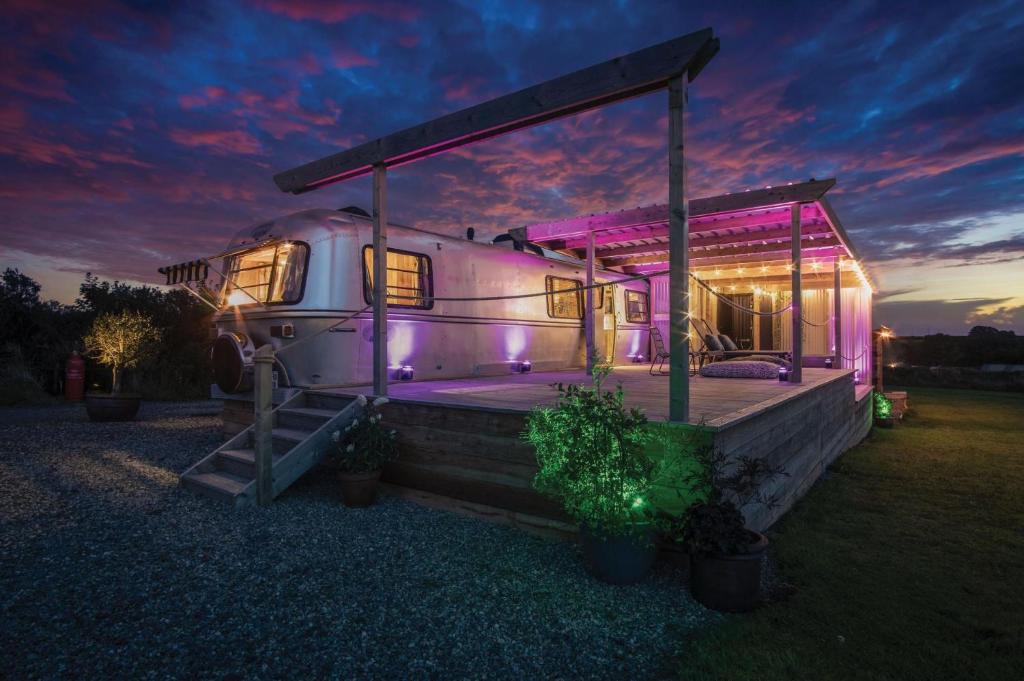 un remolque blanco grande con luces moradas. en American Airstream - Blossom Farm - Tiers Cross, en Johnston