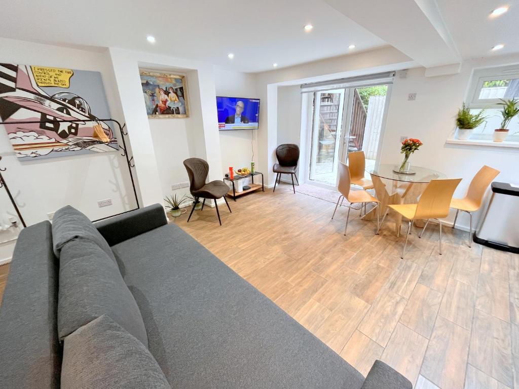 a living room with a couch and a table at Two bedroom Flat with Private Patio in Battersea in London