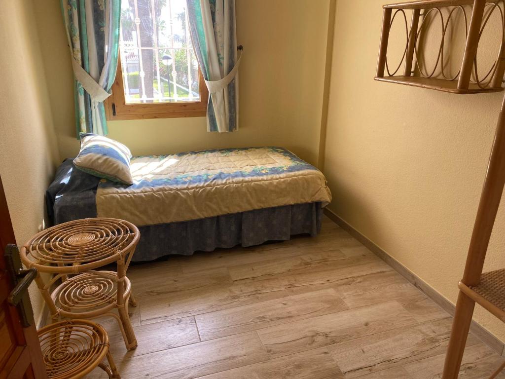 MAGNIFICO CHALET UNICO JUNTO AL MAR CALETA DE VELEZ في كاليتا دي فيليز: غرفة نوم صغيرة بها سرير ونافذة