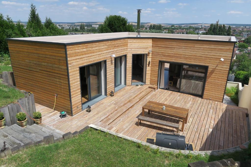 a small house with a deck with a table at Maison d'architecte avec vue sur Sens in Paron