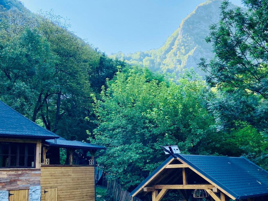 une maison avec un toit et une montagne en arrière-plan dans l'établissement BATS CAVE HUT - Transylvania - Hot-Tub - Sauna, à Sub Piatra