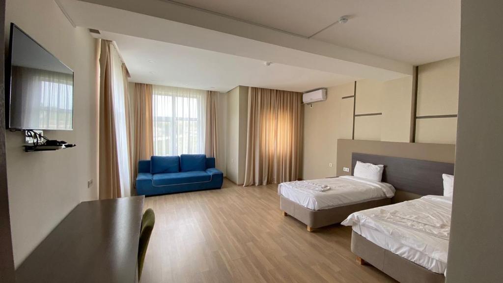 a hotel room with two beds and a blue chair at Keles Arasan SPA Hotel in Kökterek