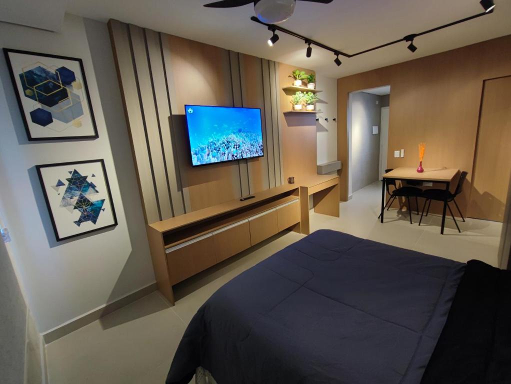 a bedroom with a bed and a flat screen tv at Canto do Bosque Home office in Campinas
