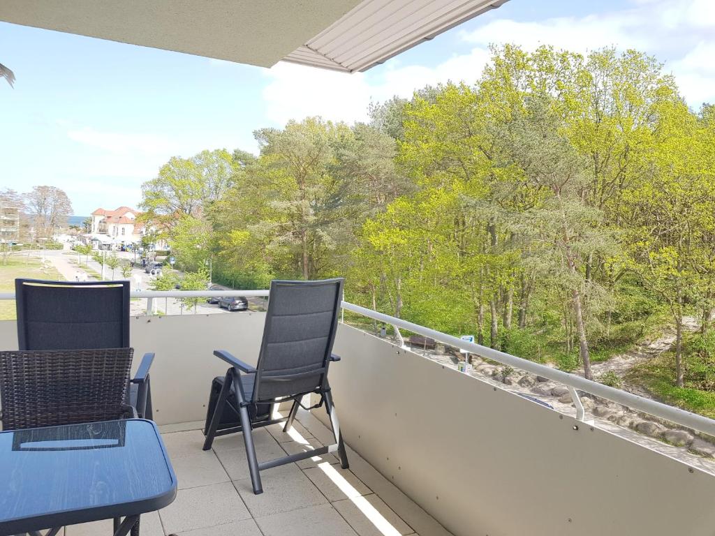 eine Terrasse mit 2 Stühlen und einem Tisch auf dem Balkon in der Unterkunft Ferienwohnung mit Ostseeblick - 190m zum Strand in Ostseebad Karlshagen