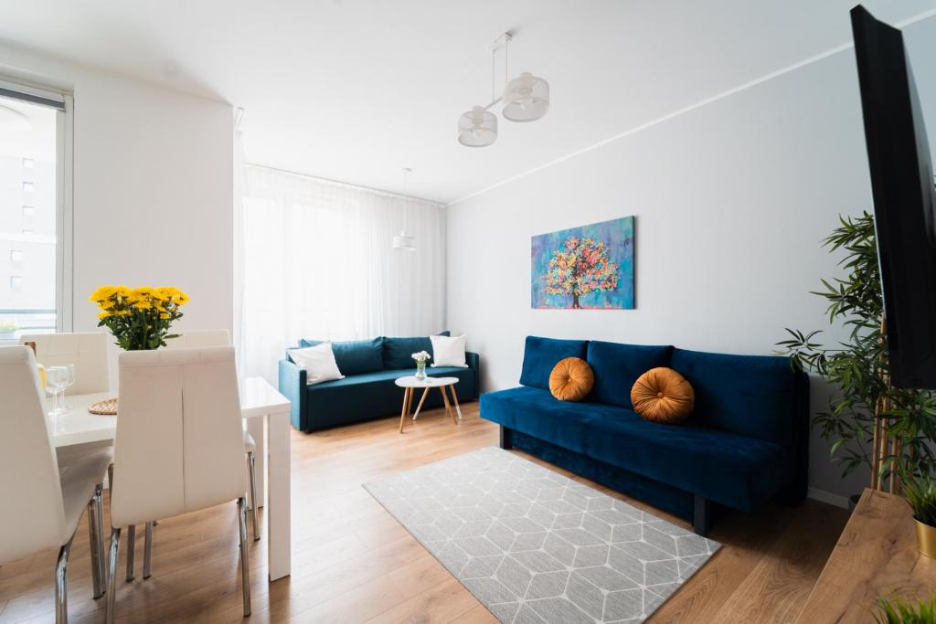 uma sala de estar com um sofá azul e uma mesa em Nice Apartment - Near Sky Tower - Private Parking em Breslávia