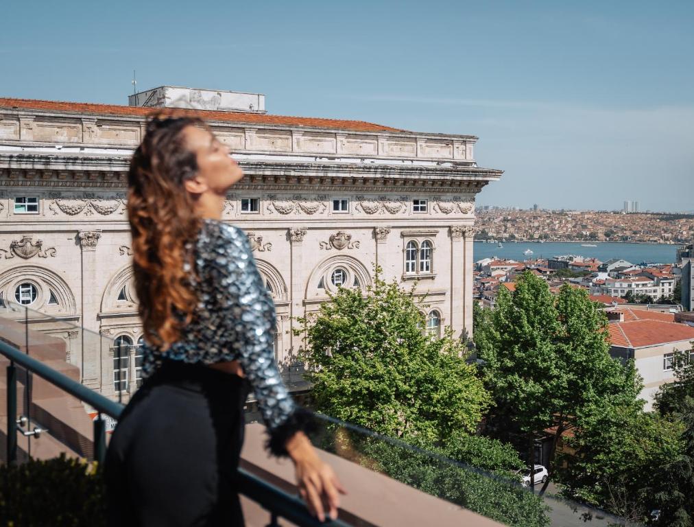 a woman walking in front of a building at Park Hyatt Istanbul - Macka Palas in Istanbul