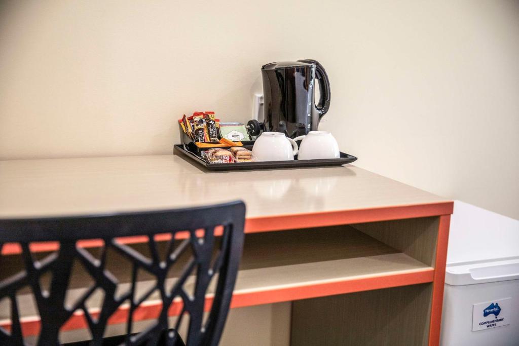 a table with a coffee maker on top of it at Nightcap at High Flyer Hotel in Bankstown