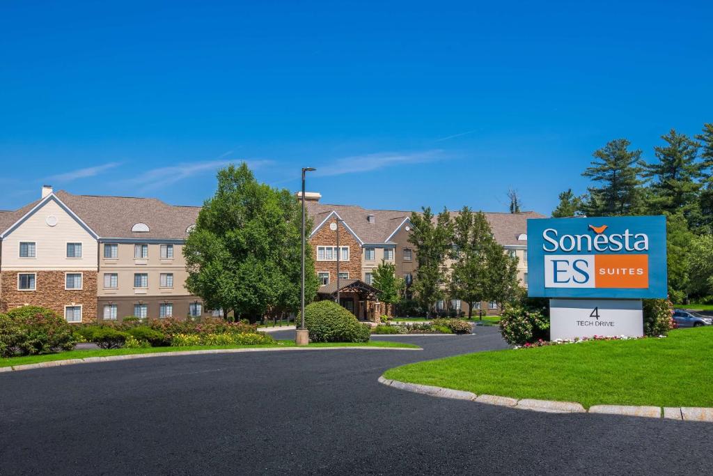Sonesta ES Suites Andover Boston في أندوفر: علامة أمام مبنى به منزل