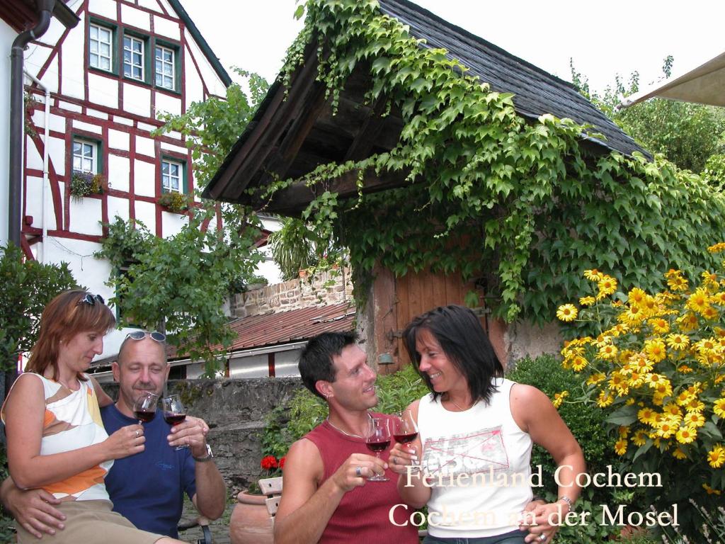 een groep mensen die wijn drinken voor een huis bij Ferienwohnungen Ferienland Cochem in Bruttig-Fankel