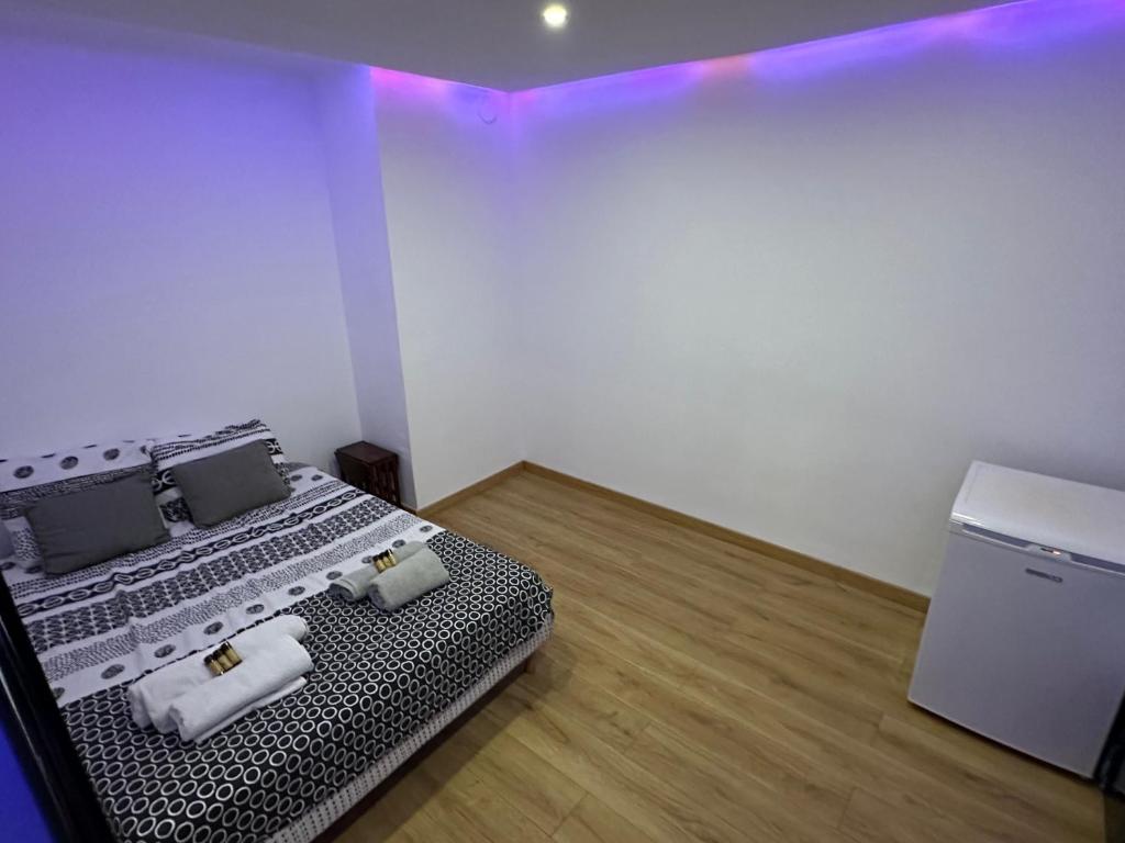 Cette chambre comprend un lit dans un dortoir doté de lumières violettes. dans l'établissement Appartement climatisé avec balcon, à Fréjus