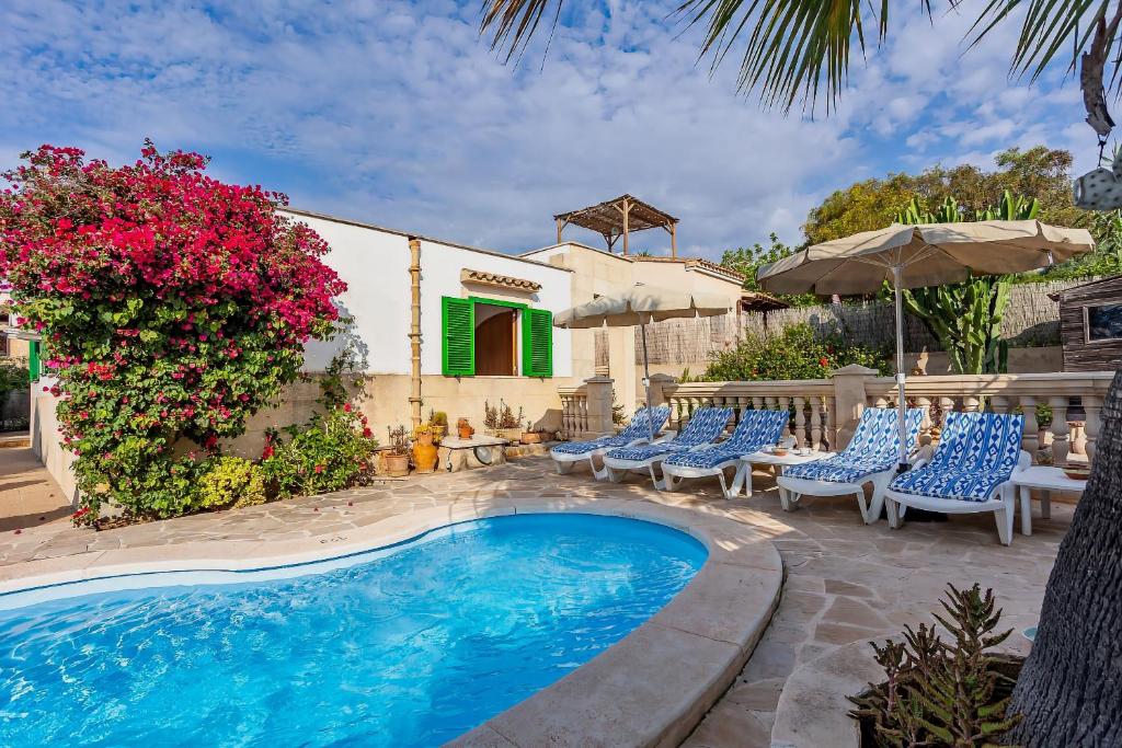 ein Resort mit einem Pool, Stühlen und Blumen in der Unterkunft Casa Sergi mit kleinem Pool und Wifi in Cala Llombards