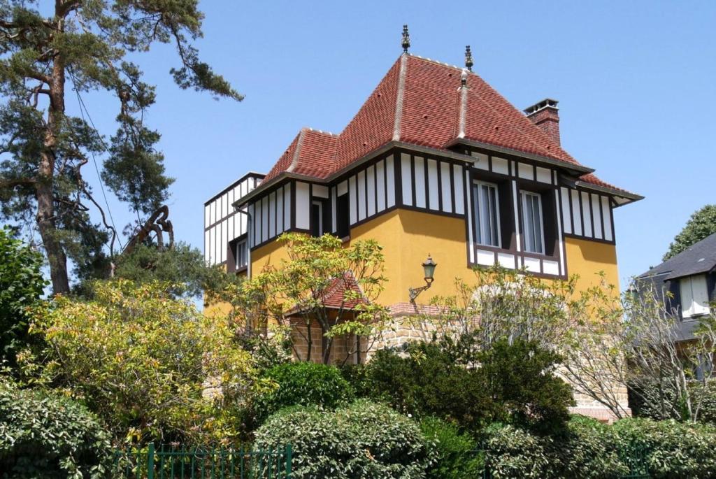 une maison jaune et blanche avec un toit rouge dans l'établissement Villa d'exception à 500 m de la plage, à Merville-Franceville-Plage