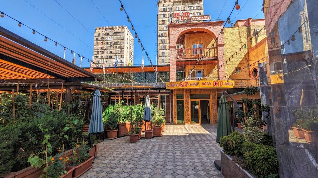 a courtyard with potted plants and umbrellas at Dkd-bridge Hotel in Tbilisi City