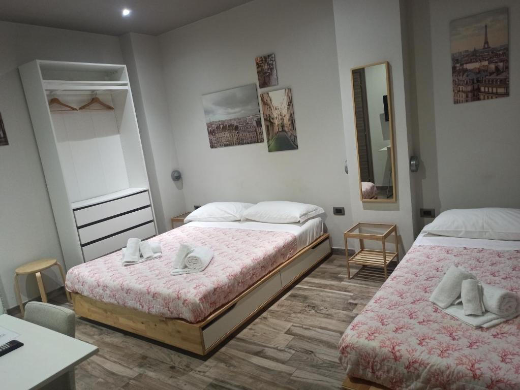 a bedroom with two beds and a table and a mirror at Le Mirage in Chieti
