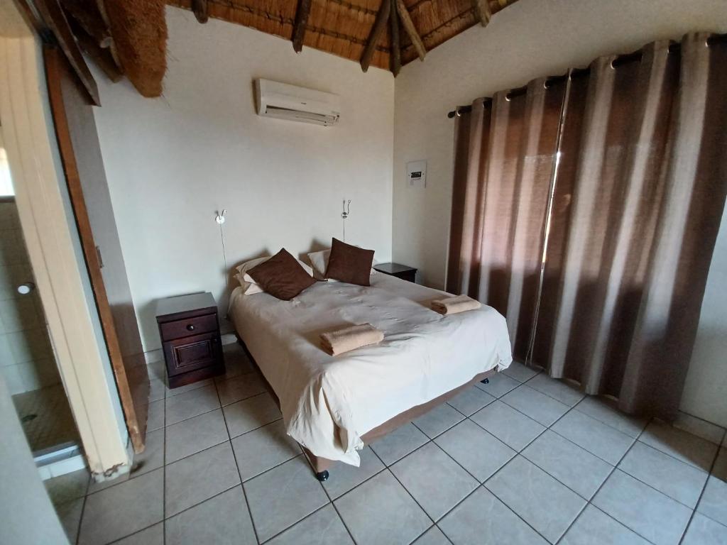 a bedroom with a bed in a room at Umziki Chalets in Mkuze