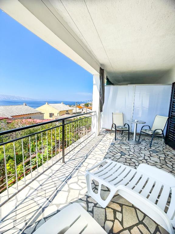 a balcony with a white bench and a view of the ocean at Zimmer - Room - Magdalena in Senj