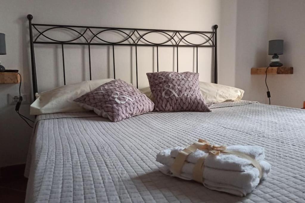 een bed met een witte deken en kussens erop bij a casa di Sara in Sassari