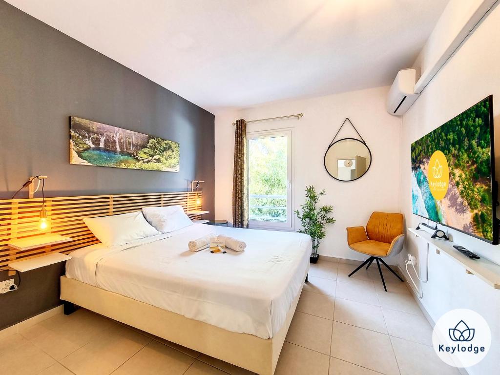 a bedroom with a bed and a desk and a tv at T3 - Tropical Lodge - 3 étoiles - 65m2 - Saint-Pierre in Saint-Pierre