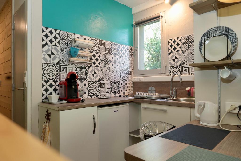 una cocina con armarios blancos y una pared azul en Studio à Courchevel Moriond, en Saint-Bon-Tarentaise