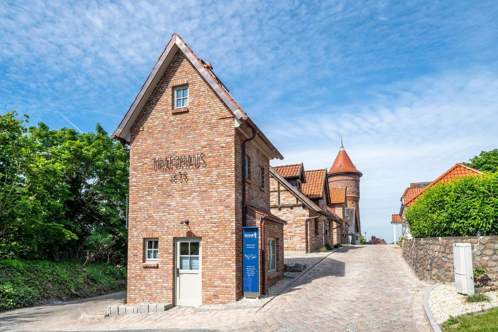 an old brick building with a tower in the background at Apart Hotel Wasserturm in Bad Segeberg