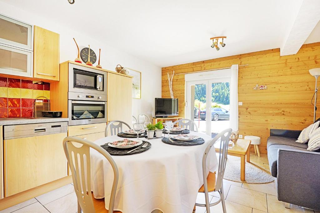 eine Küche und ein Esszimmer mit einem Tisch und Stühlen in der Unterkunft Aux Flocons de la Mauselaine - Station de ski in Gérardmer