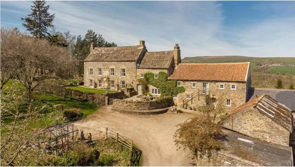 an estate with a large stone house in the countryside at Coves House Farm B&B in Wolsingham