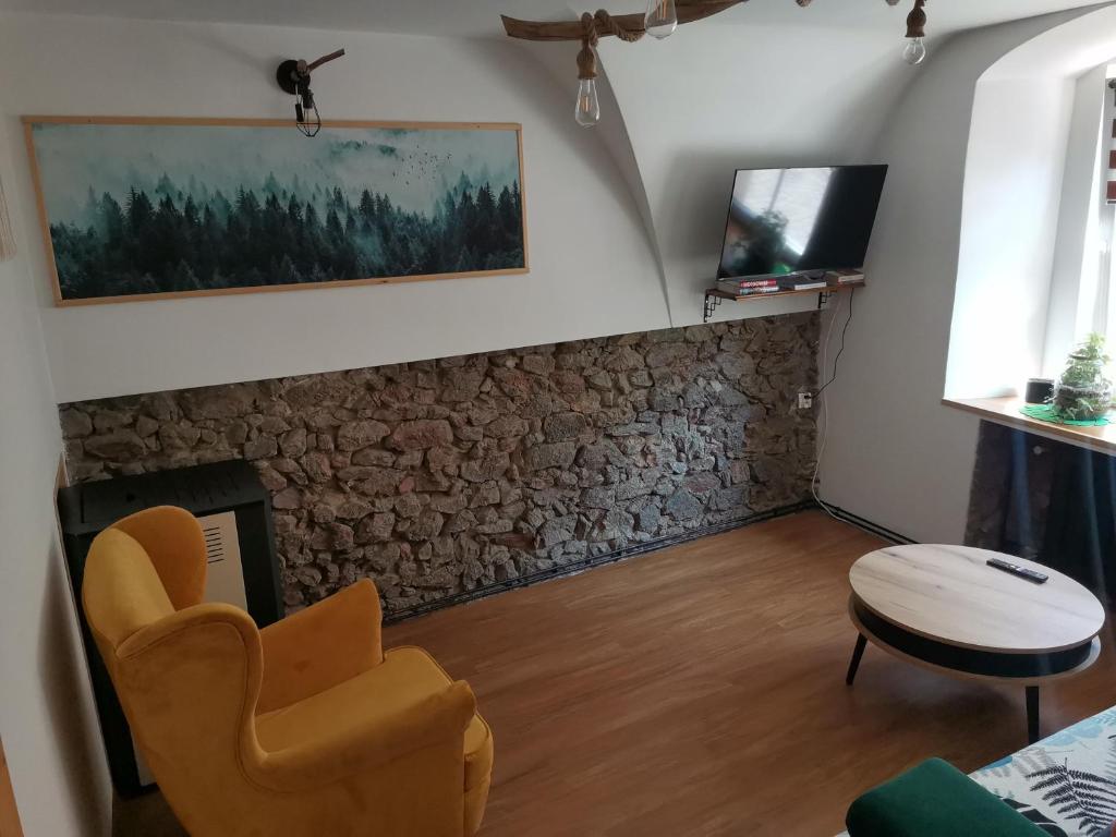 - un salon avec une cheminée en pierre et une chaise dans l'établissement Przystanek Srebrna Góra, à Srebrna Góra