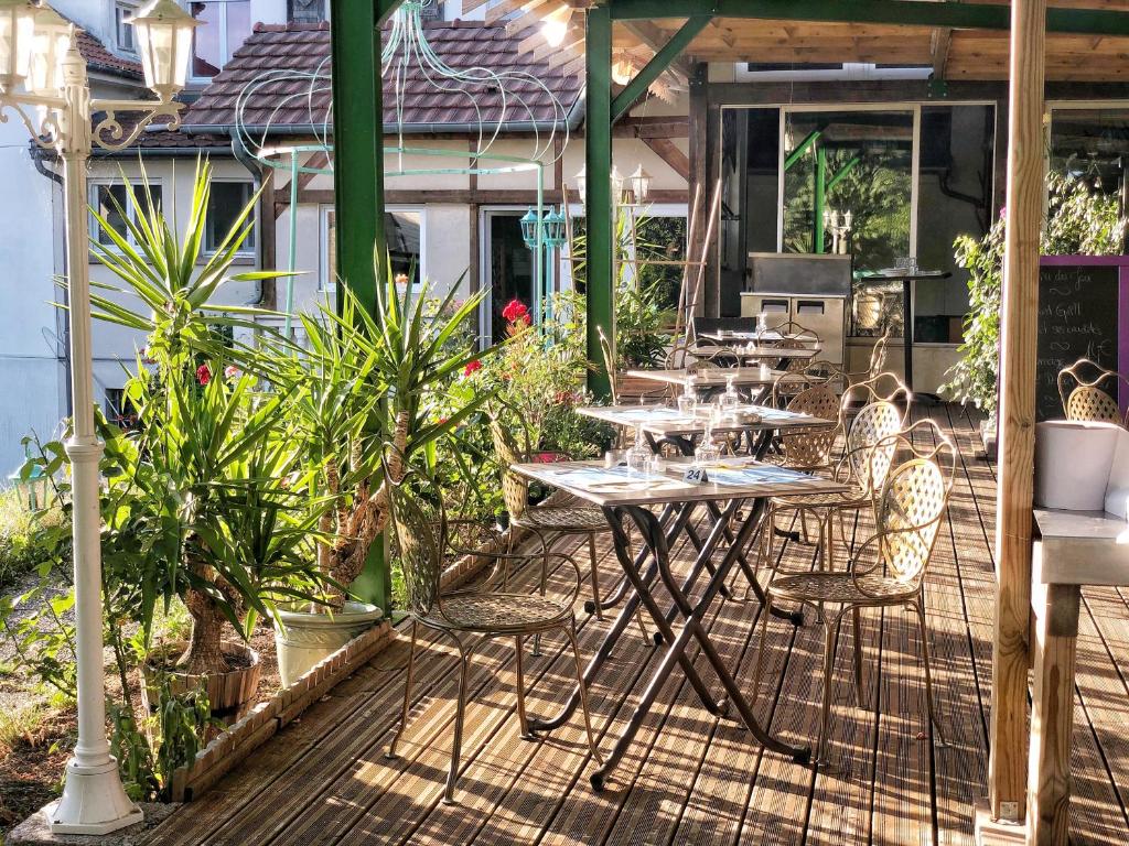 eine Gruppe von Tischen und Stühlen auf einer Terrasse in der Unterkunft Hôtel Le Floride 