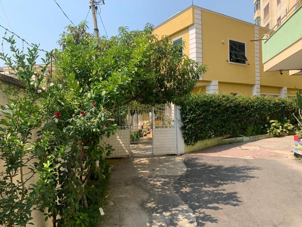 een poort naar een gebouw met een bos planten bij Apartment with garden in the center of Durres in Durrës