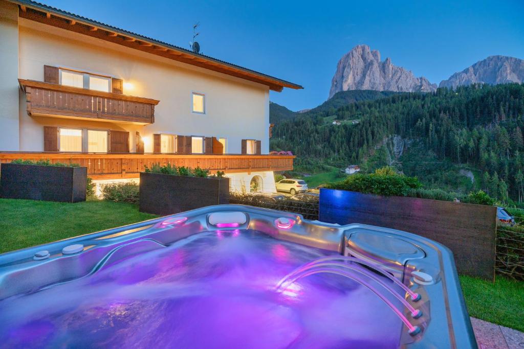 una bañera de hidromasaje en el patio trasero de una casa en Hotel Ciamp, en Santa Cristina Valgardena