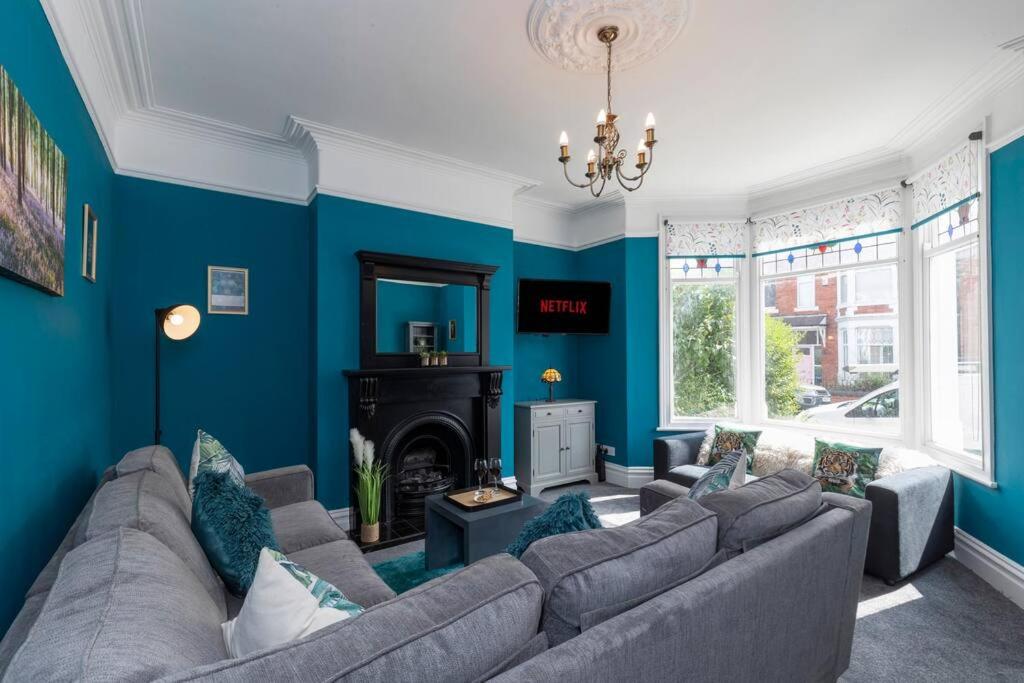 ein Wohnzimmer mit blauen Wänden und einem Sofa in der Unterkunft Big House, and a lot to give! in Middlesbrough