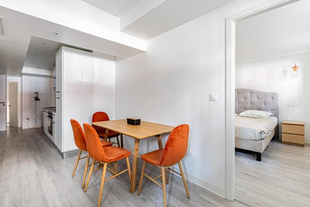 une salle à manger avec des chaises orange et une table dans l'établissement Strasbourg centre Oberlin, à Strasbourg