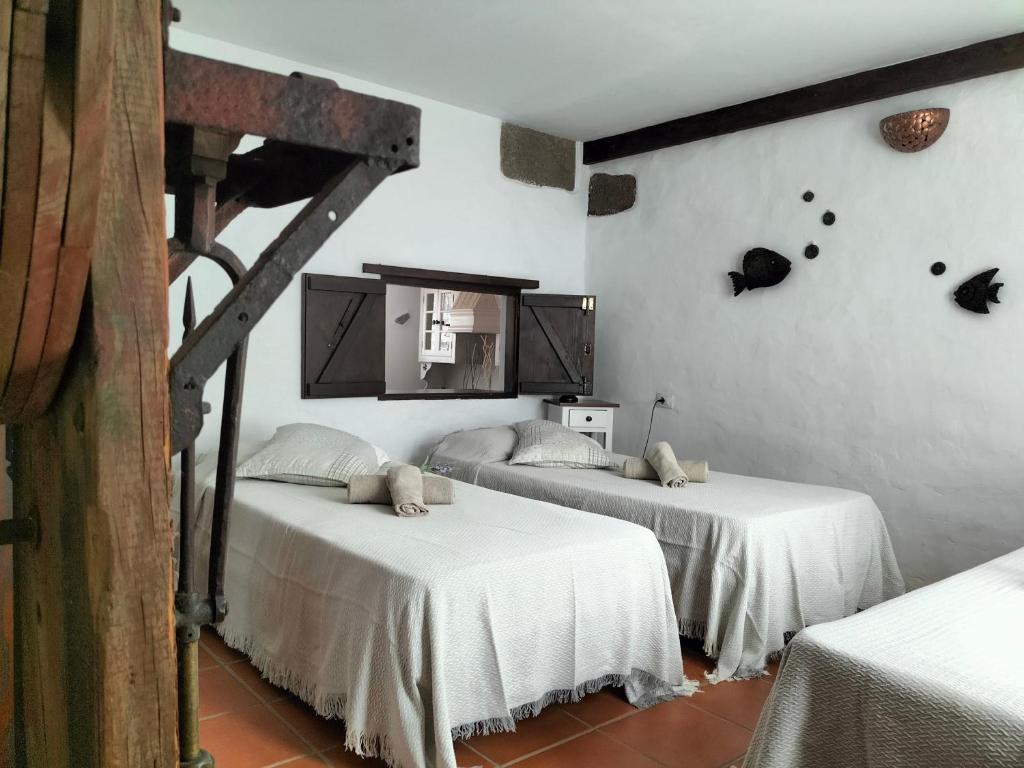 two beds in a room with white walls at Casa Rural "La Molina" in Máguez