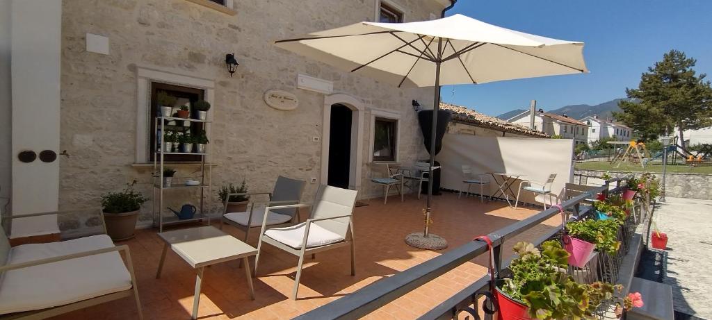eine Terrasse mit einem Tisch und einem Sonnenschirm in der Unterkunft Casa di Carmine 1915 - Solo Adulti in Gamberale