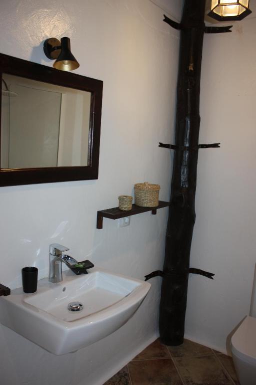 a bathroom with a sink and a mirror on the wall at Casa Rural "La Molina" in Máguez