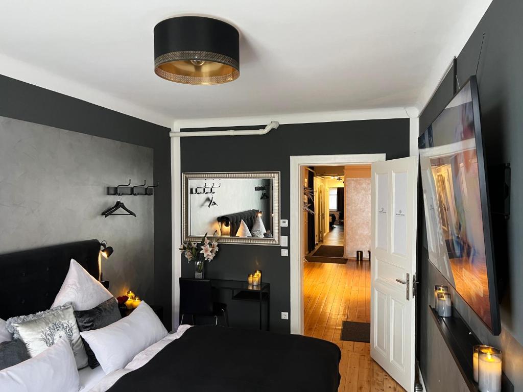 a bedroom with a bed and a black wall at Platin City Apartment in Hamburg