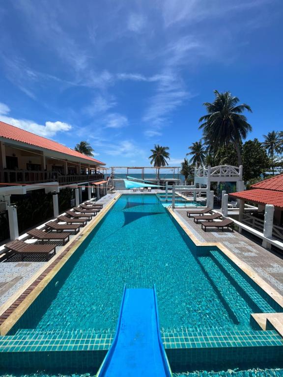 a pool at the resort with lounge chairs and palm trees at Paradise Bungalows in Haad Rin
