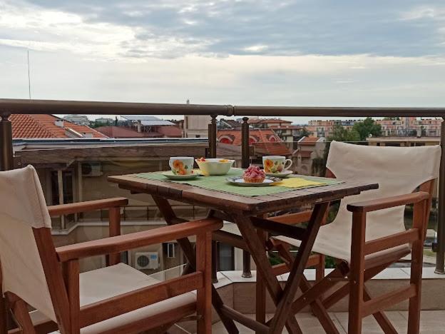 una mesa en un balcón con una comida en Голям апартамент с прекрасна гледка кьм морето en Ravda
