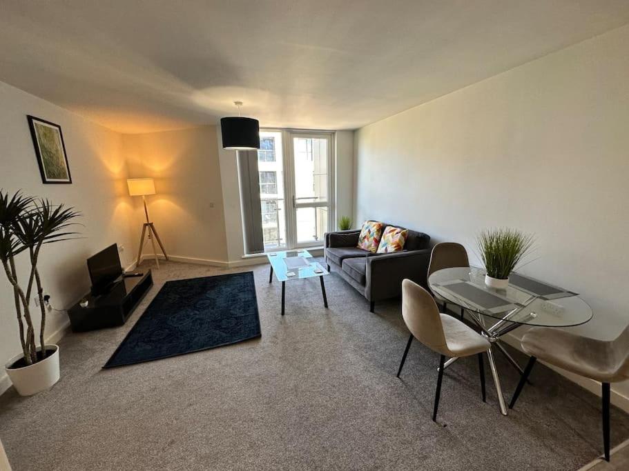 a living room with a couch and a table at Cosy 2 Bed Apt Sleeps 4+Balcony in Manchester