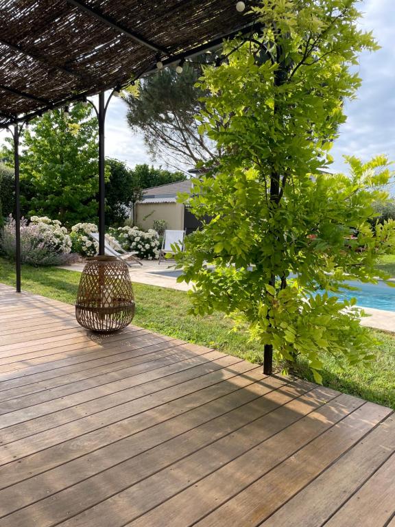 a wooden deck with a tree and a bench at Suite 671 in Reyrieux