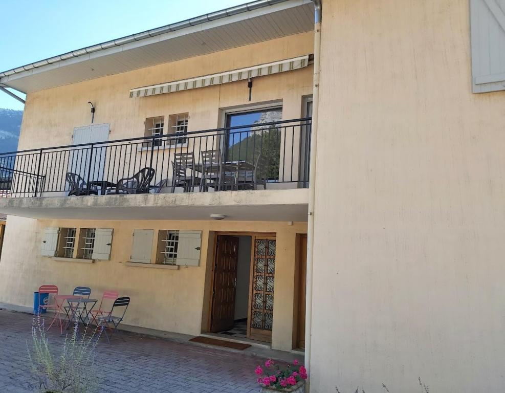 a building with a balcony with chairs and tables at APPARTEMENT T3 BEAU RIVAGE in Nantua
