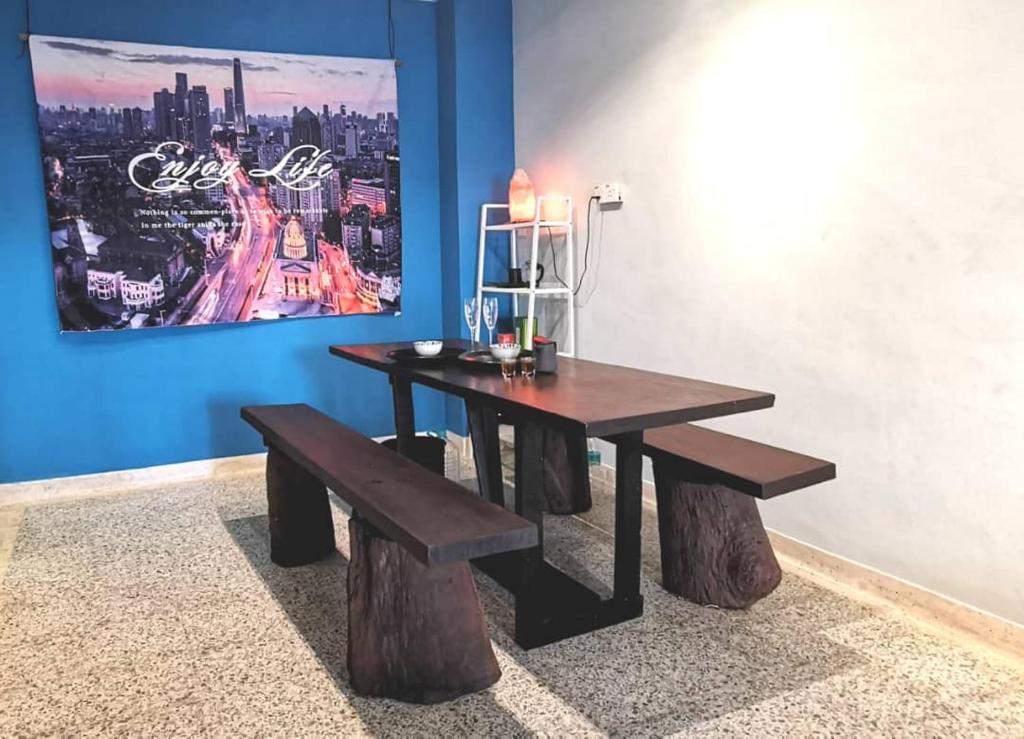 drewniany stół i ławka w pokoju z obrazem w obiekcie AL Cozy Seri Kuantan Home w mieście Kuantan